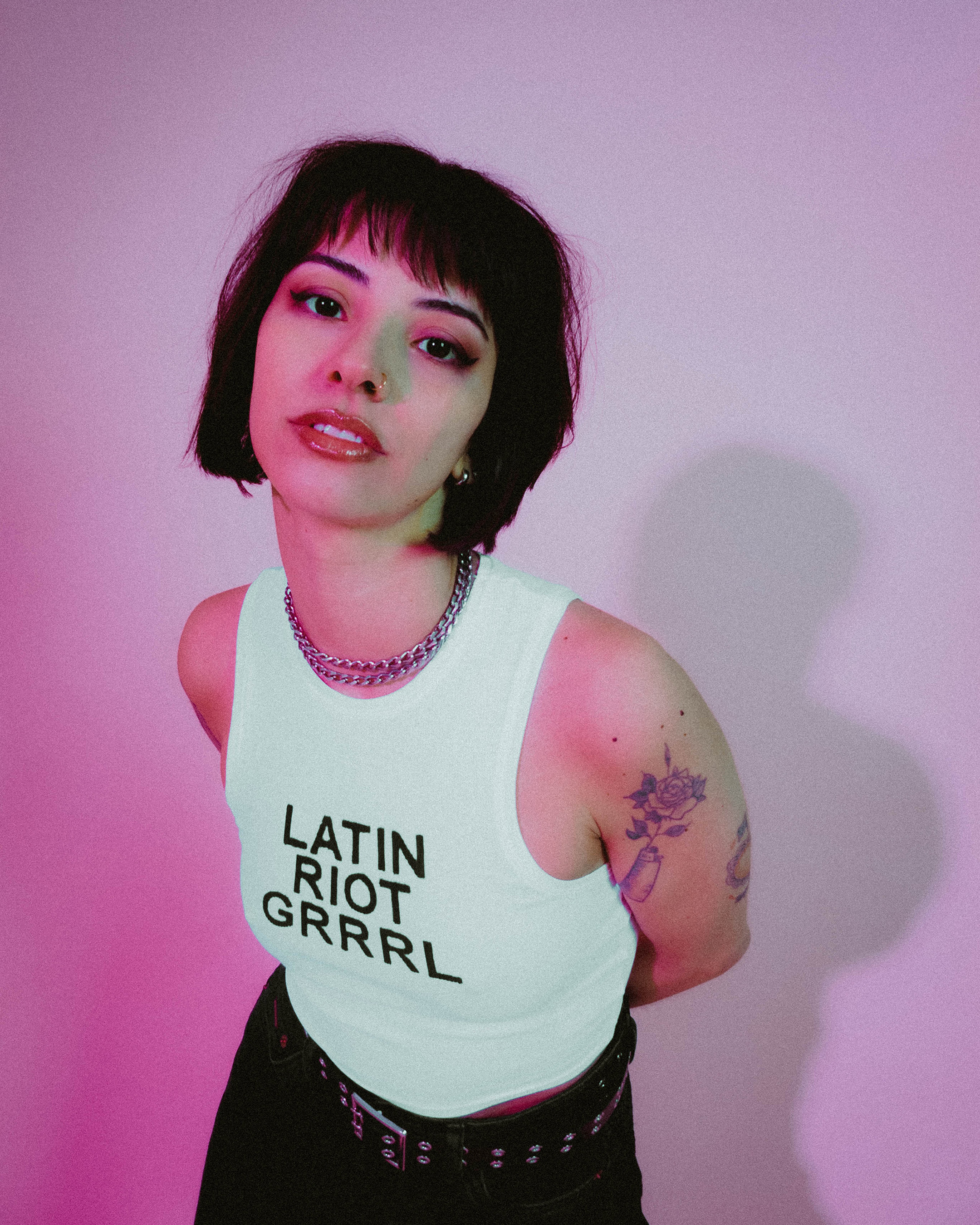 Karen Dió in a tank top that reads ‘Latin Riot Grrrl’, photo by Bridie Cummings